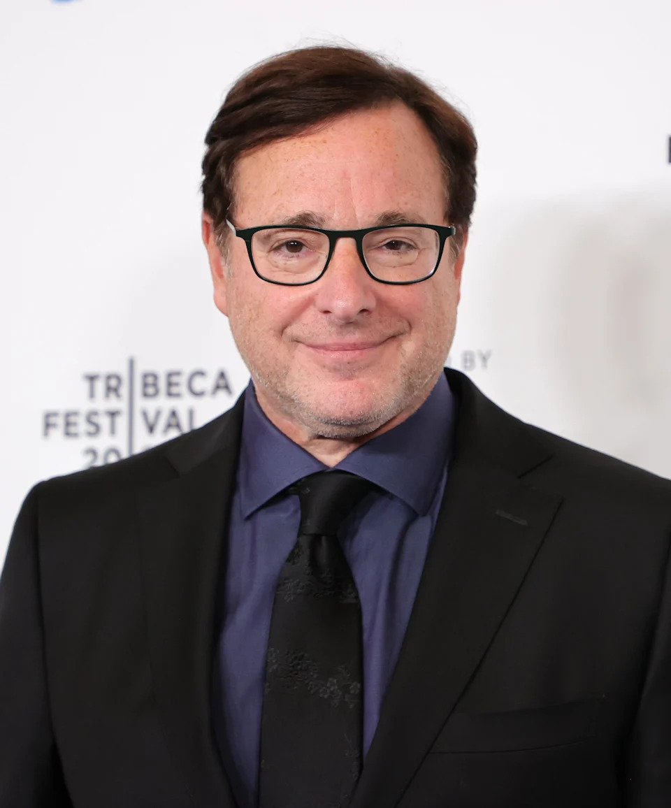Person in glasses and a suit at a film festival event. Festival logos displayed on the backdrop