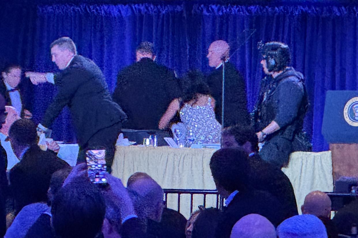 US Secret Service agents surround President Donald Trump as he is taken from the stage after a shooting incident outside the ballroom during the White House Correspondents Dinner (Mark Schiefelbein/AP) (AP)