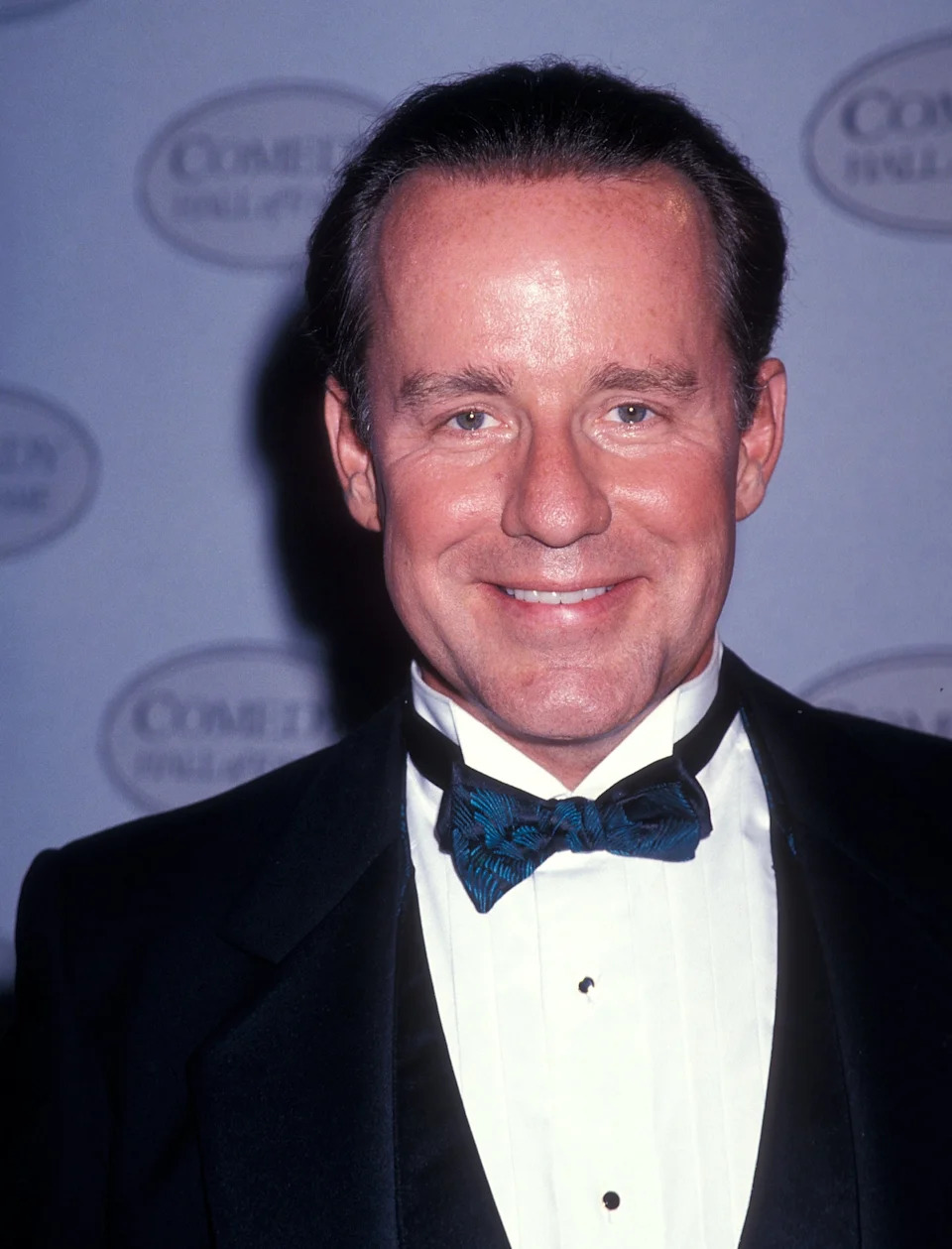 Phil Hartman in a tuxedo with a bow tie at a formal event