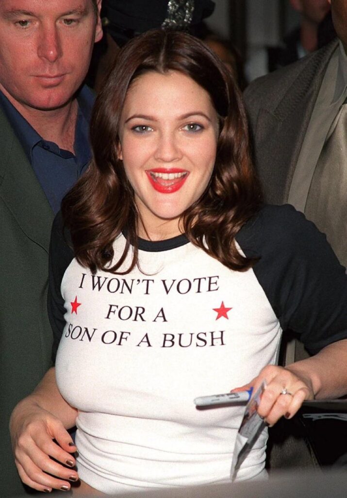 Drew Barrymore in 2004 wears a shirt that says, “I won’t vote for a son of a Bush.”