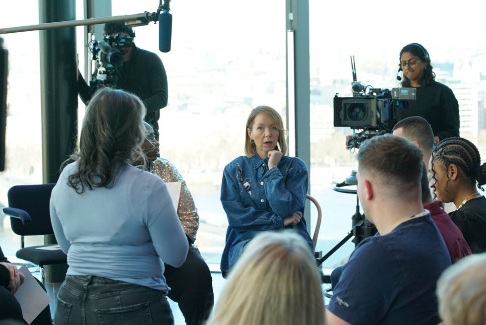 interview or discussion setting with multiple participants and a film crew