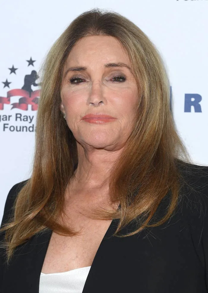 Caitlyn Jenner wearing a blazer and top at an event with the Sugar Ray Leonard Foundation backdrop