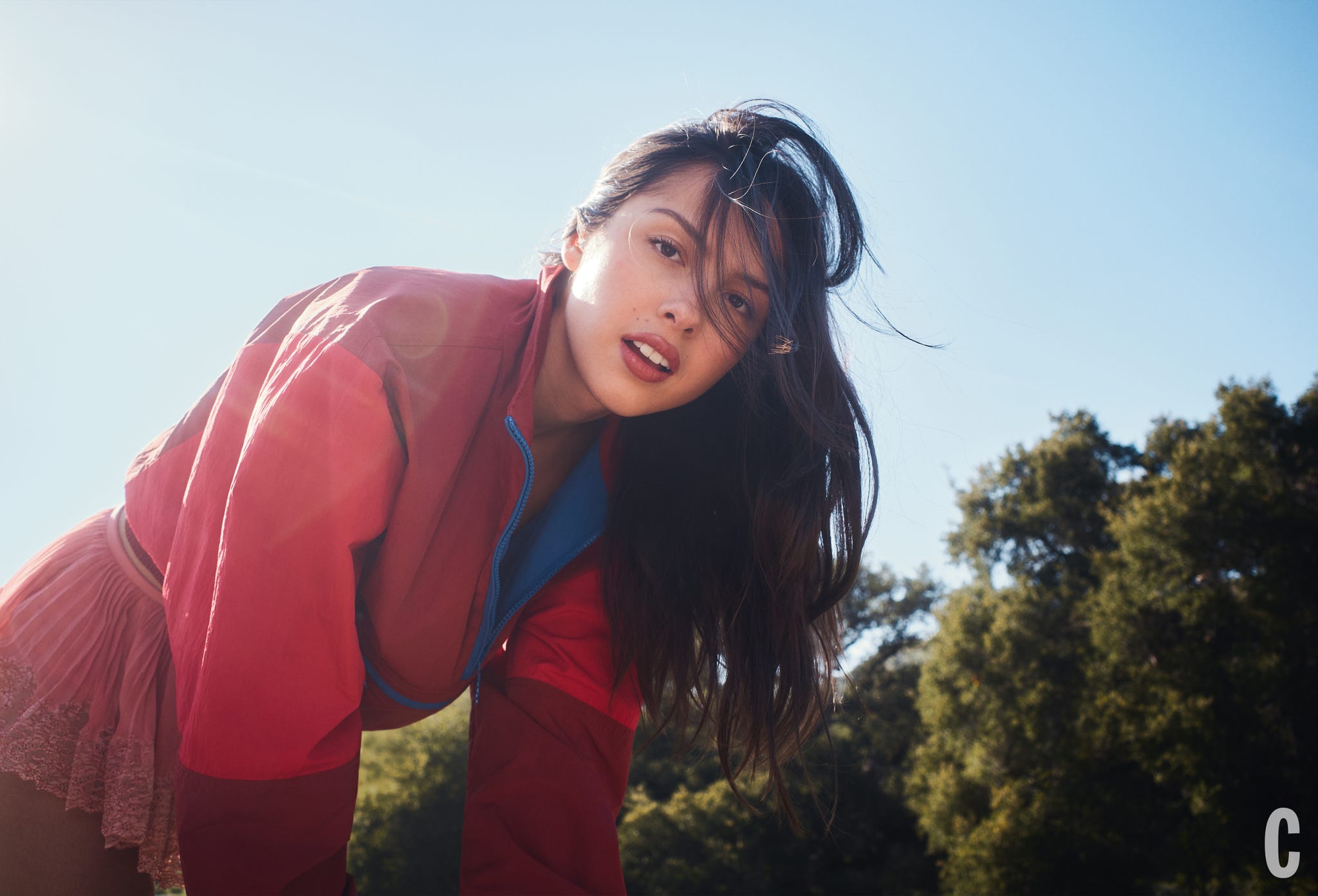 Person in a colorful outfit bending forward outdoors.