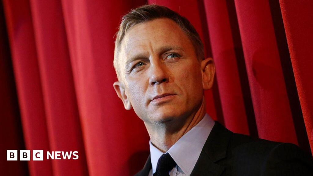 Daniel Craig pictured on the red carpet for the James Bond film Spectre; he is wearing a black suit.