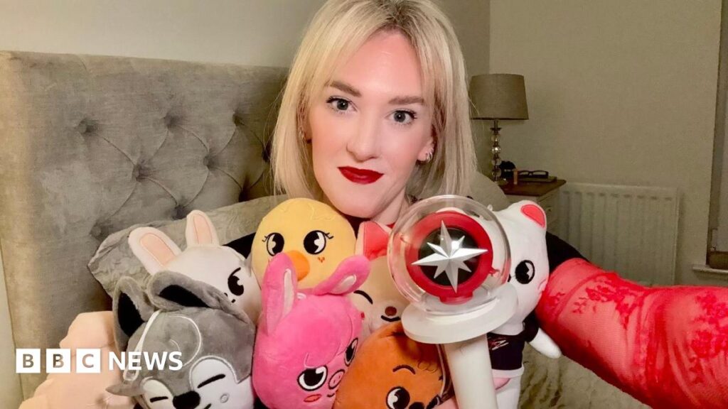 A blonde woman holding stuffed toys