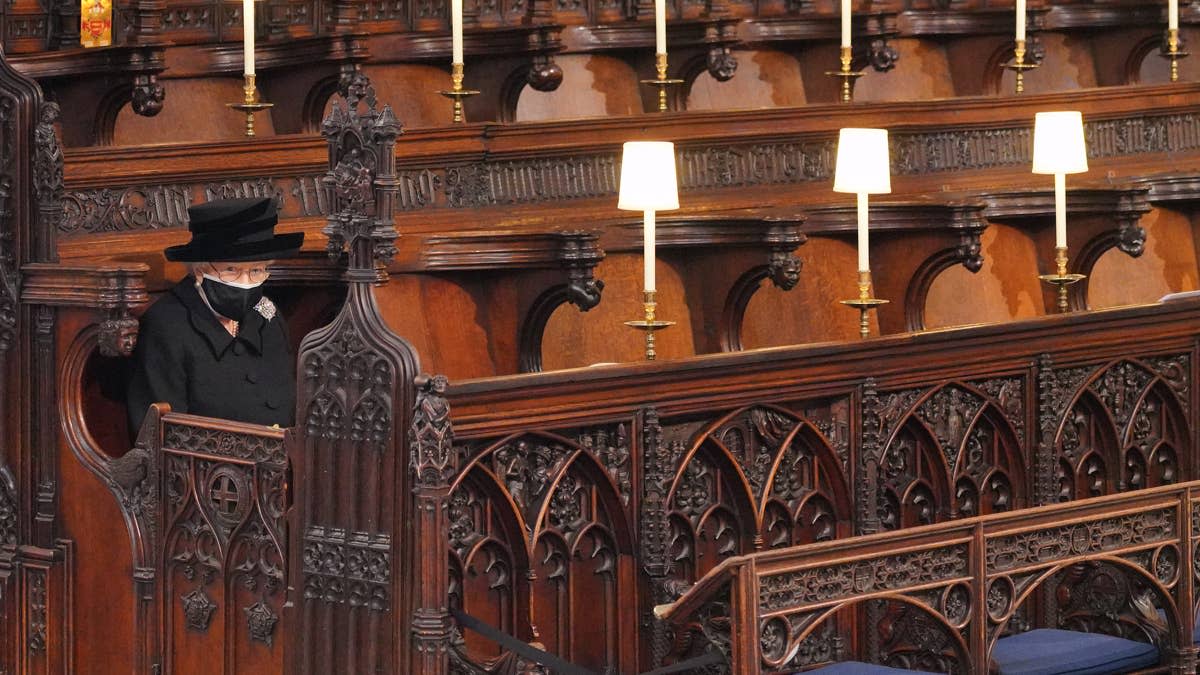 WINDSOR, ENGLAND - APRIL 17: Queen Elizabeth II takes her seat during the funeral of Prince Philip, Duke of Edinburgh in St George's Chapel at Windsor Castle on April 17, 2021 in Windsor, England. Prince Philip of Greece and Denmark was born 10 June 1921, in Greece. He served in the British Royal Navy and fought in WWII. He married the then Princess Elizabeth on 20 November 1947 and was created Duke of Edinburgh, Earl of Merioneth, and Baron Greenwich by King VI. He served as Prince Consort to Queen Elizabeth II until his death on April 9 2021, months short of his 100th birthday. His funeral takes place today at Windsor Castle with only 30 guests invited due to Coronavirus pandemic restrictions. (Photo by Jonathan Brady - WPA Pool/Getty Images)Jonathan Brady - WPA Pool&sol;Getty Images