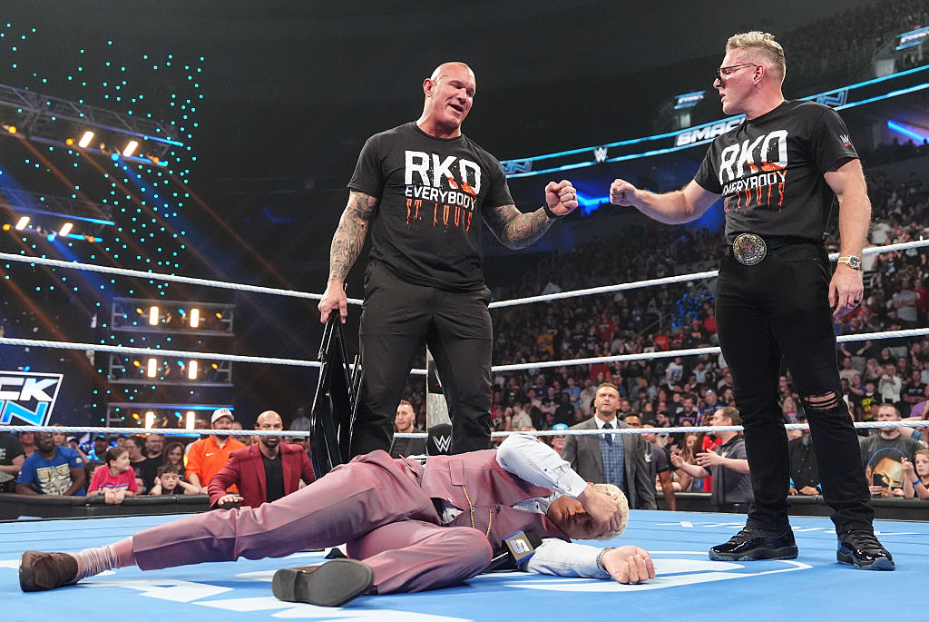 Randy Orton and Pat McAfee stand over Cody Rhodes during a WWE SmackDown segment