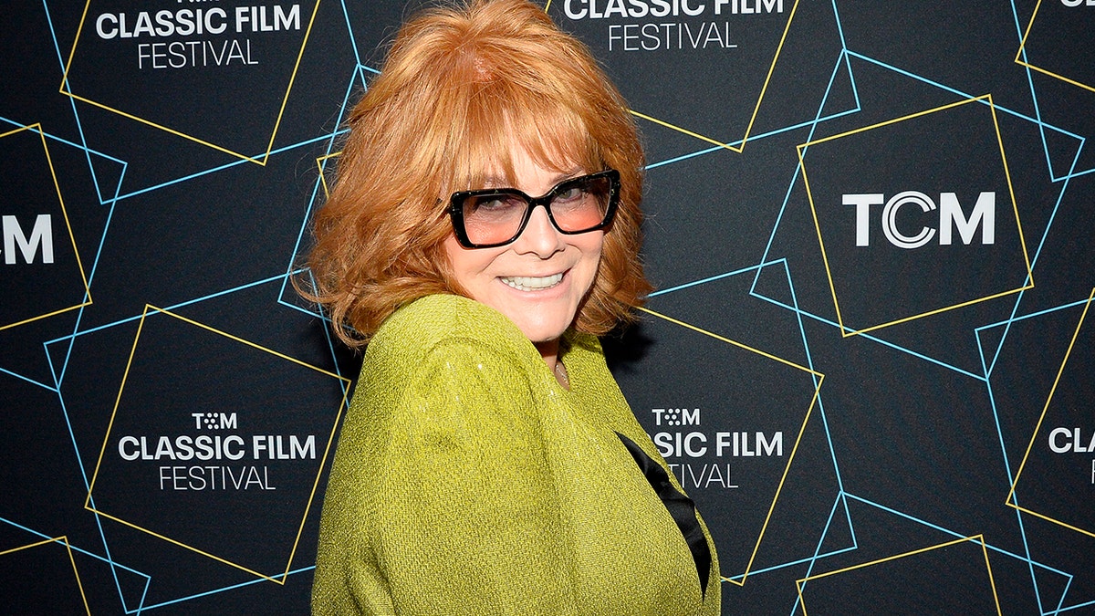 Ann-Margret smiling wearing a bright green blazer and black shirt at a film festival screening