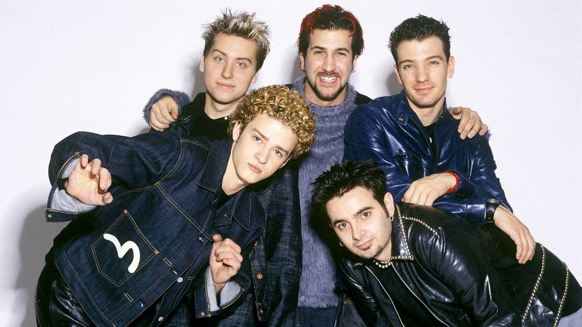 The band members of *NSYNC posing together in matching attire in New York City.