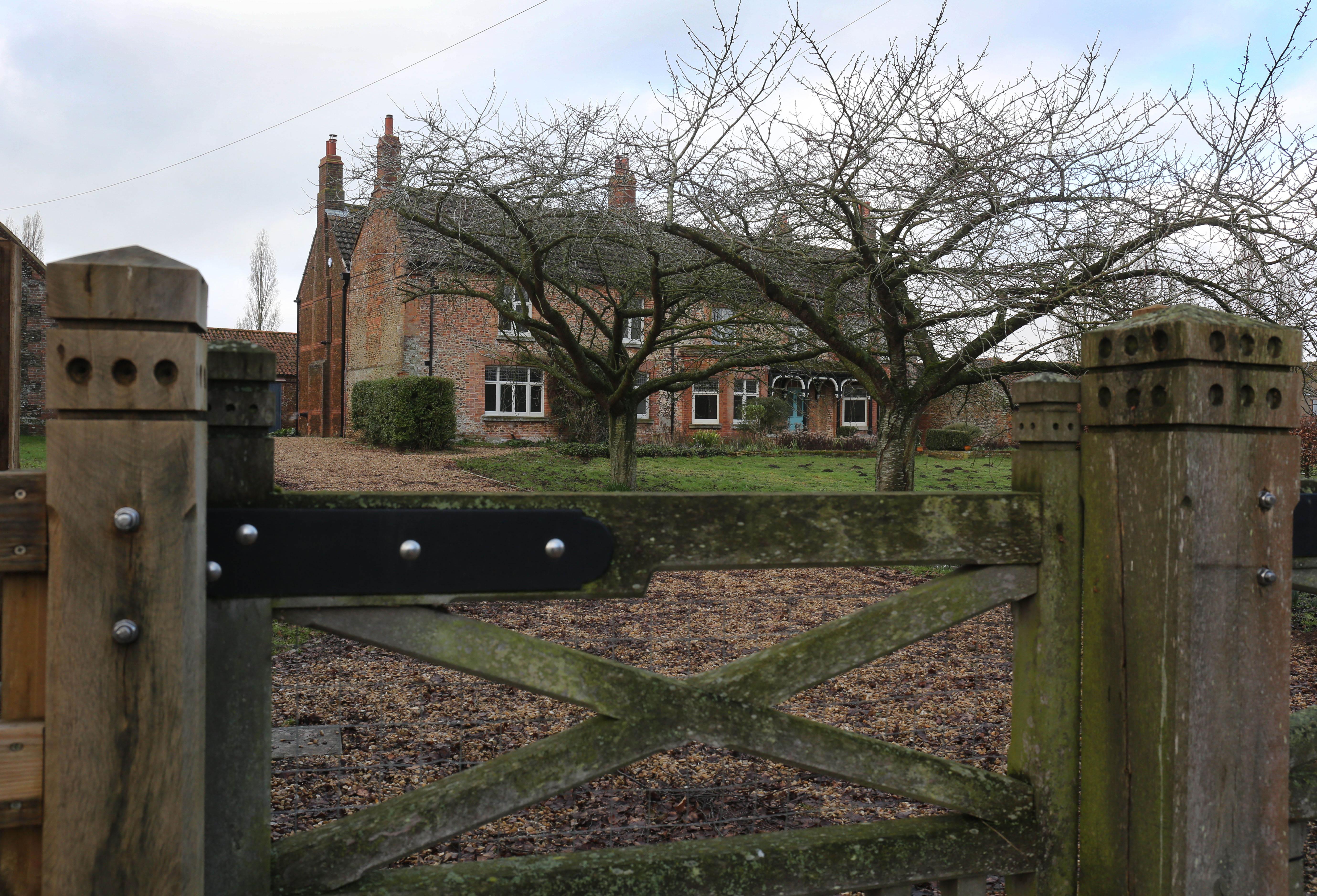 The exterior of Marsh Farm and a wooden fence
