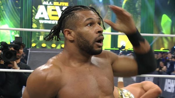 A shocked wrestler, Kevin Knight, stands in the ring with an expression of surprise, celebrating his unexpected victory. The AEW logo is visible in the background, emphasizing the event's context.