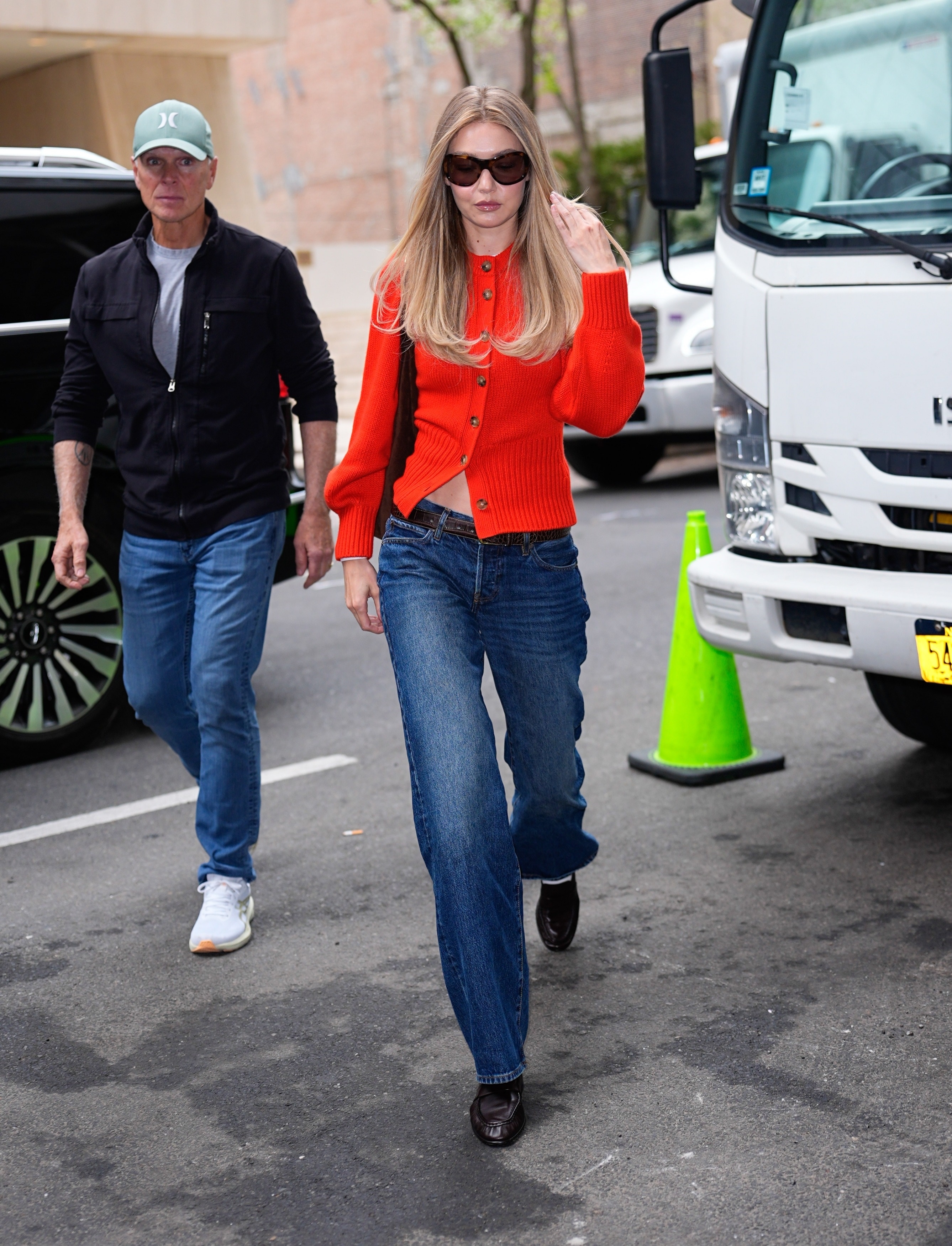Gigi Hadid wearing a red cardigan and jeans