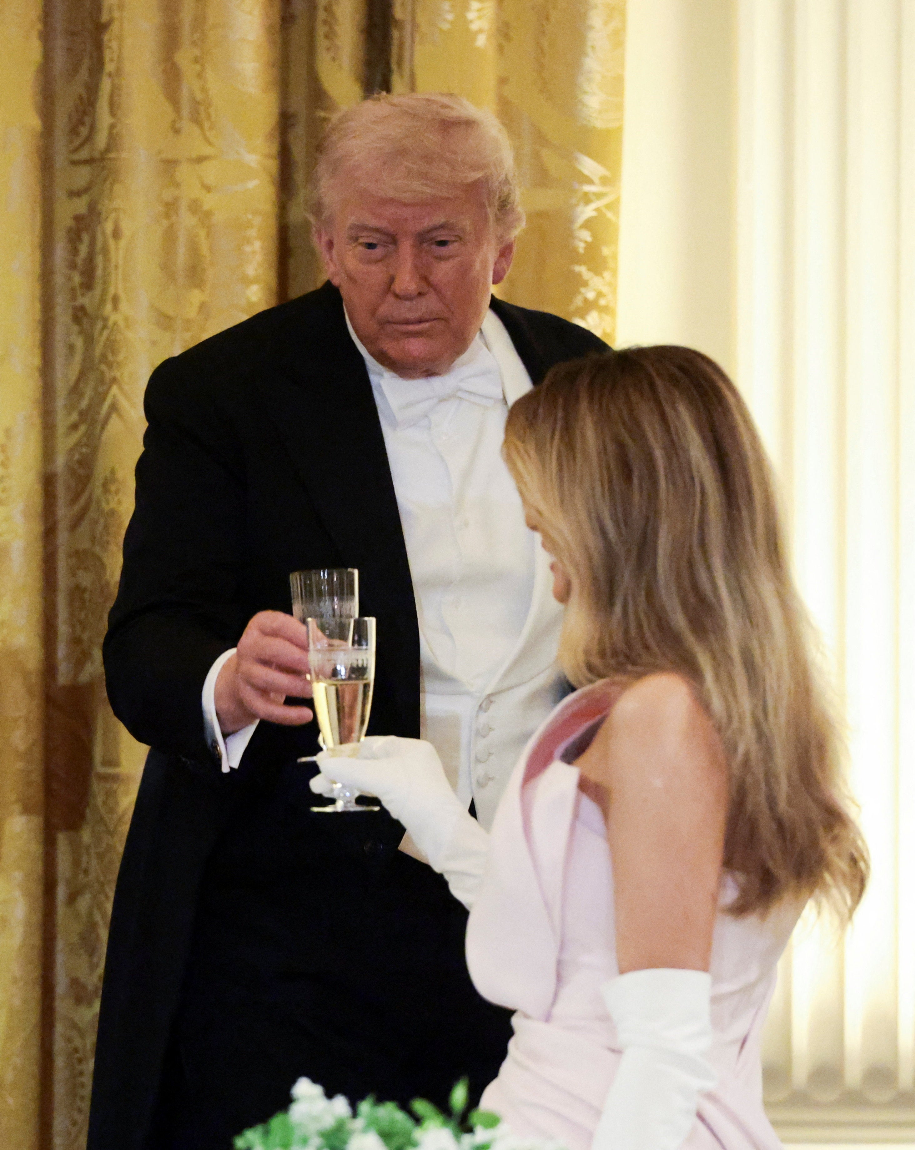 The president and first lady Melania Trump raise their glasses during the White House state dinner