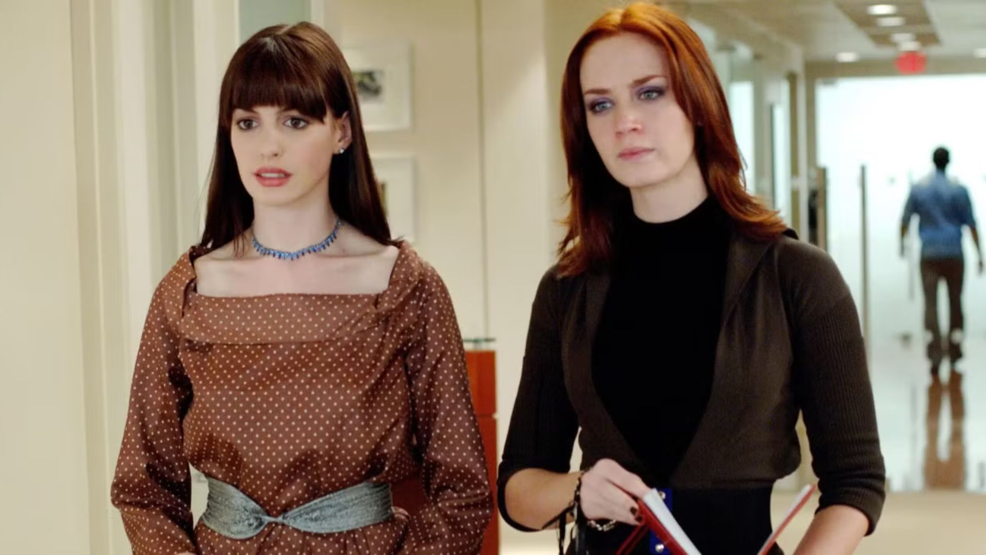 Anne Hathaway and Emily Blunt stand next to each other looking concerned