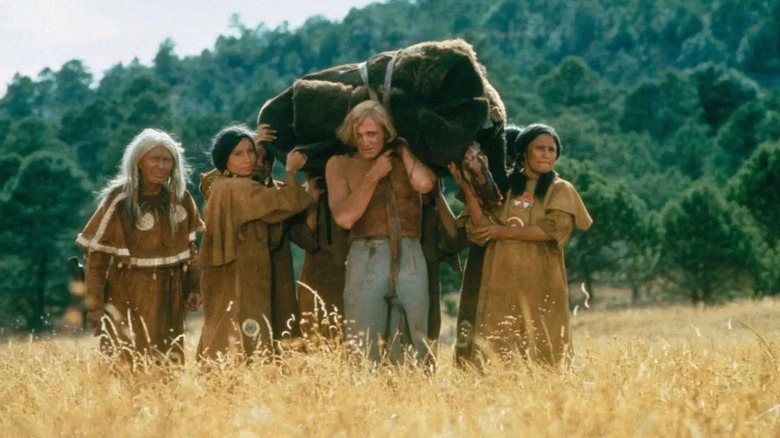 John Morgan (Richard Harris) and tribespeople walking through a field in 