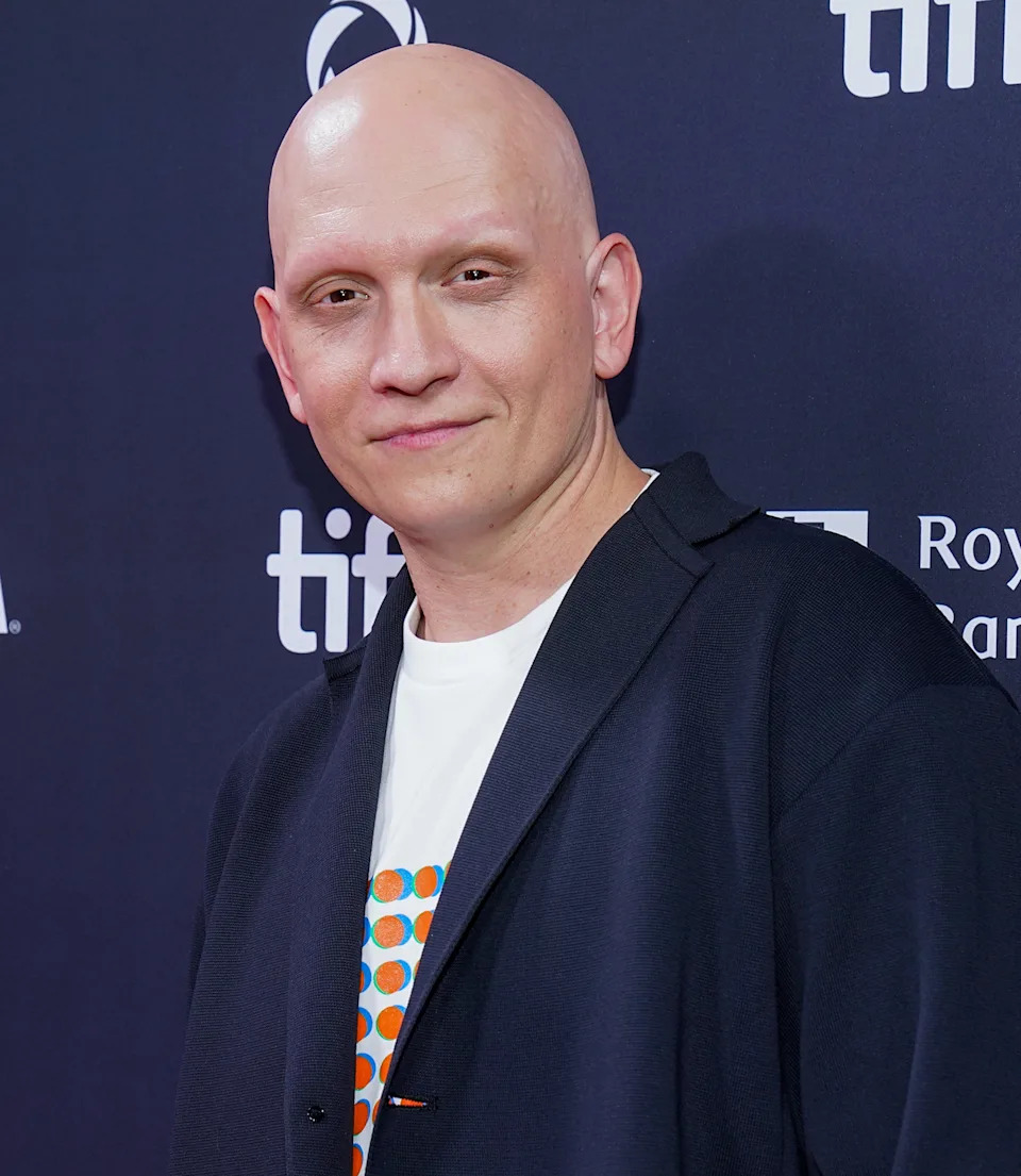 A person on a red carpet wearing a black blazer over a graphic t-shirt, attending an event with visible VISA and TIFF logos in the background