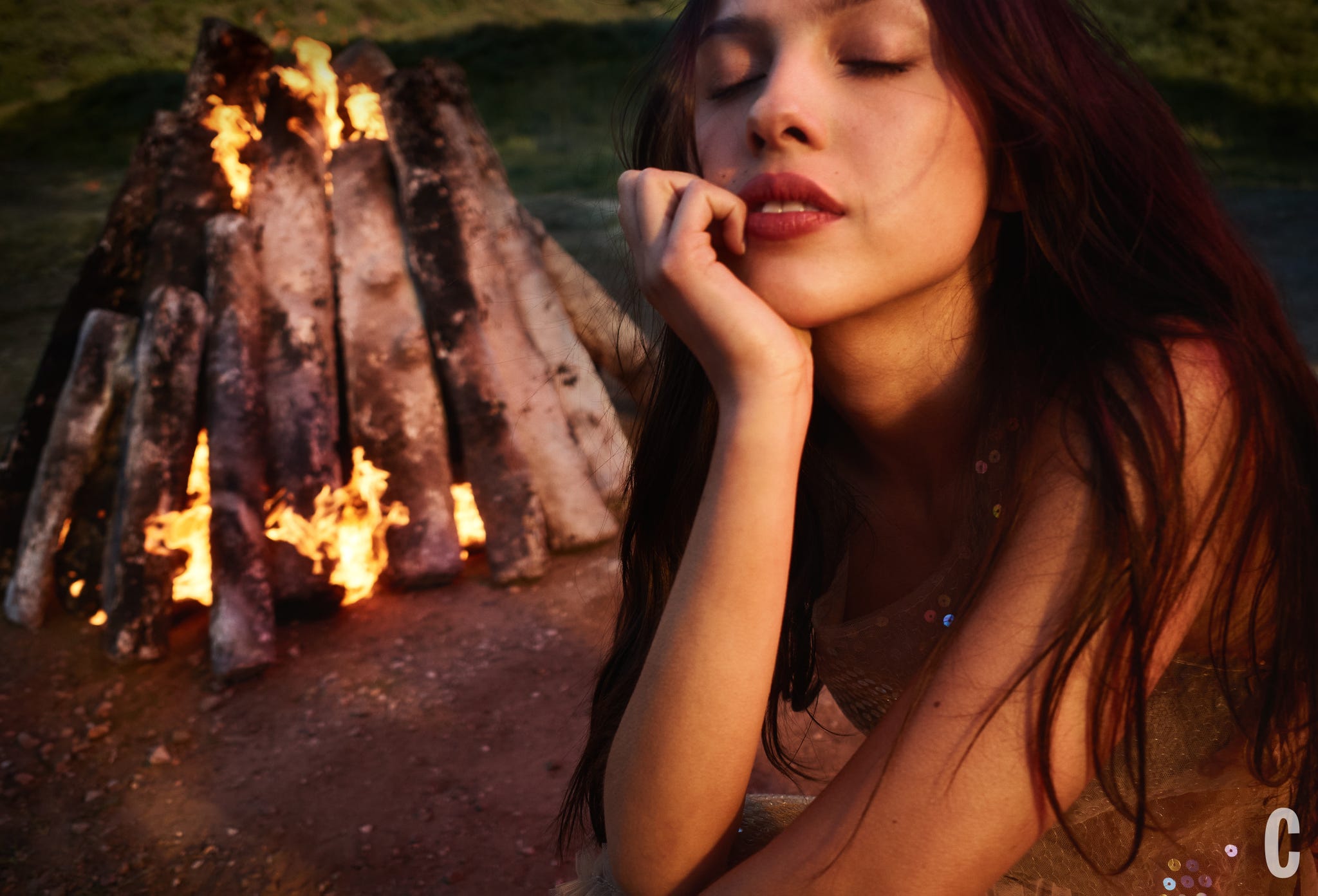 A person sitting near a bonfire.