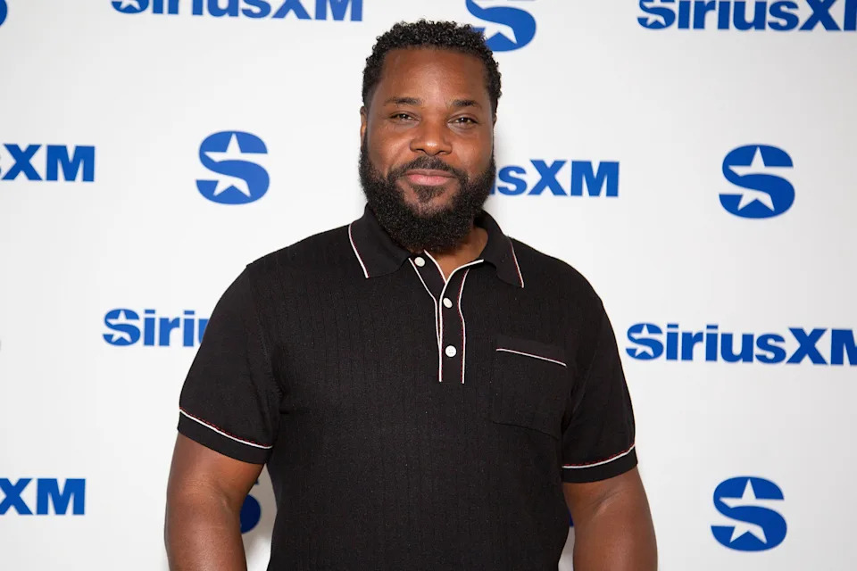 Man in a collared shirt poses in front of a SiriusXM backdrop