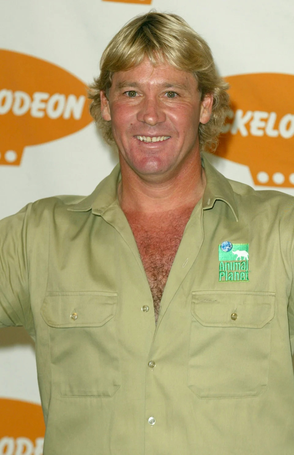 Steve Irwin smiling at a Nickelodeon event wearing a safari-style shirt with an Animal Planet logo