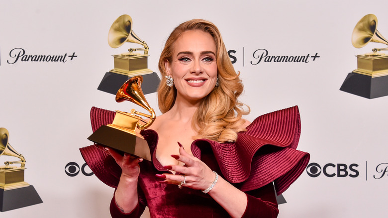 Adele posing with a Grammy award