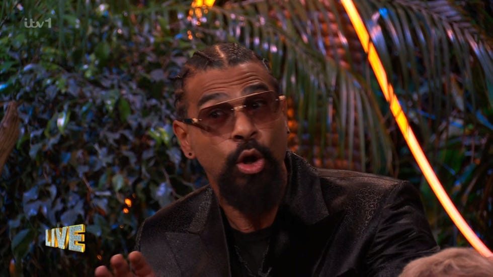 a person gesturing while seated with obscured facial features