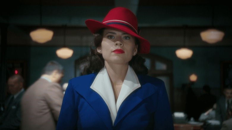Hayley Atwell as Peggy Carter enters the SSR office in New York City with her signature red hat and blue blazer in Agent Carter