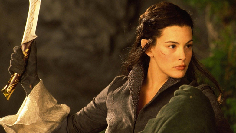 Arwen (Liv Tyler) holds up a sword in The Lord of the Rings: The Fellowship of the Ring