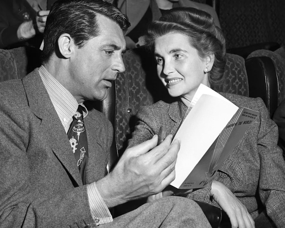 Cary Grant and Barbara Hutton in formal attire conversing in a theater setting