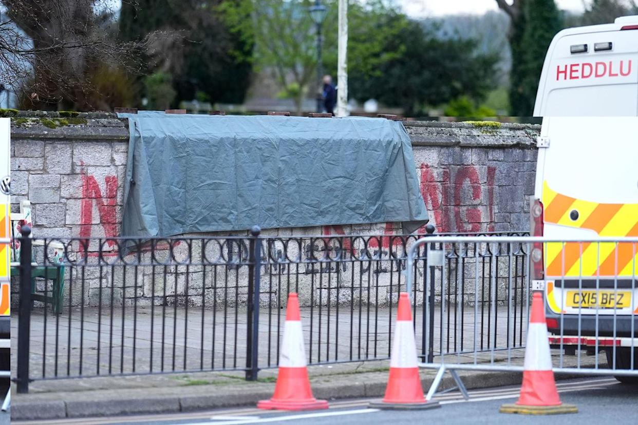 A tarp covering the spray painted graffiti on the wall outside St Asaph Cathedral in North Wales on April 2, 2026.Credit: Alamy