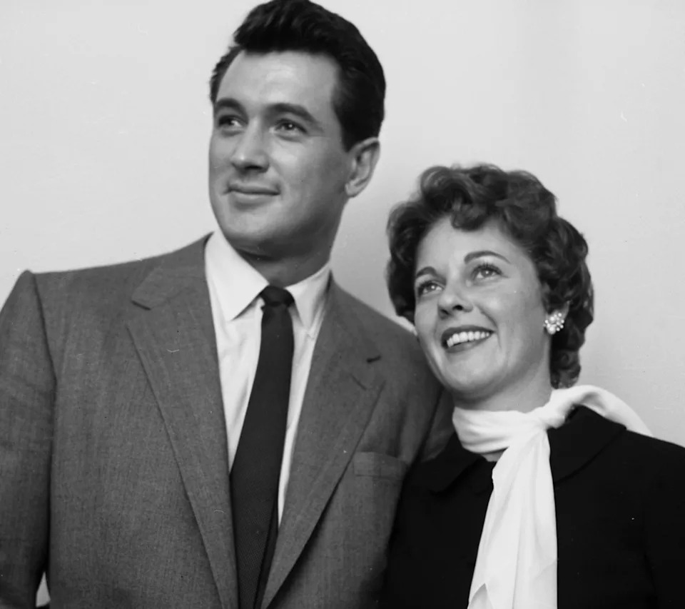 Rock Hudson and Phyllis Gates smile for the camera, standing close together