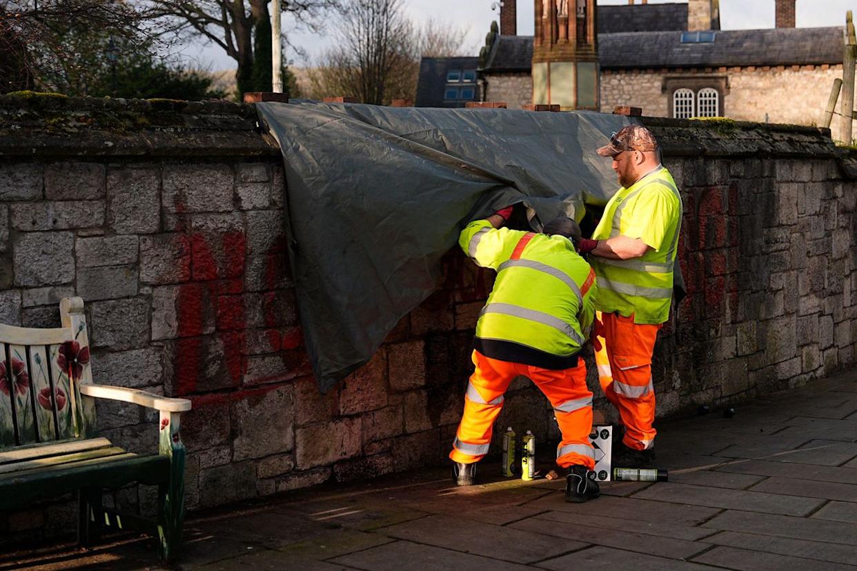 Workers clean off spray painted graffiti on the wall outside St Asaph Cathedral on April 2, 2026.Credit: Alamy