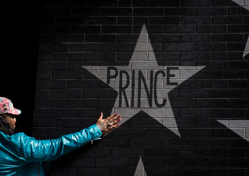 A woman touches the Prince star on the wall outside the First Avenue nightclub on April 21, 2016 in Minneapolis, Minnesota.