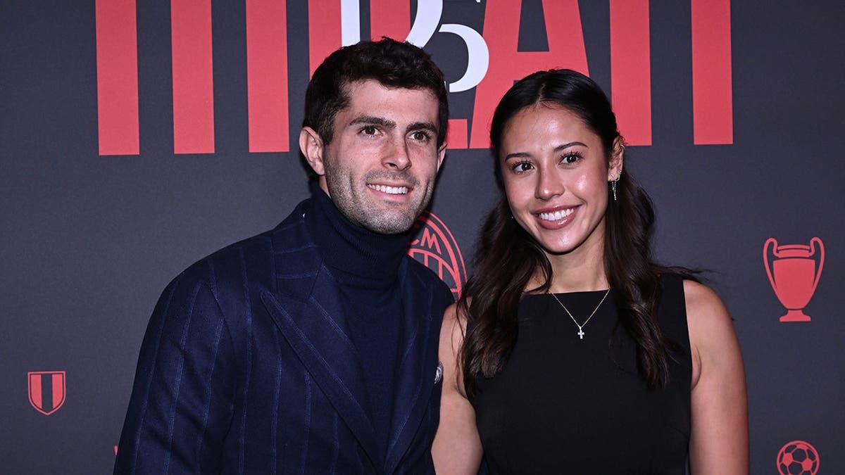 Christian Pulisic and Alexa Melton standing together at an event in Milan