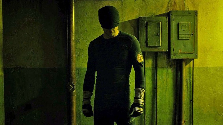 Charlie Cox as Daredevil is beat up in his original black costume after the infamous hallway fight in Daredevil