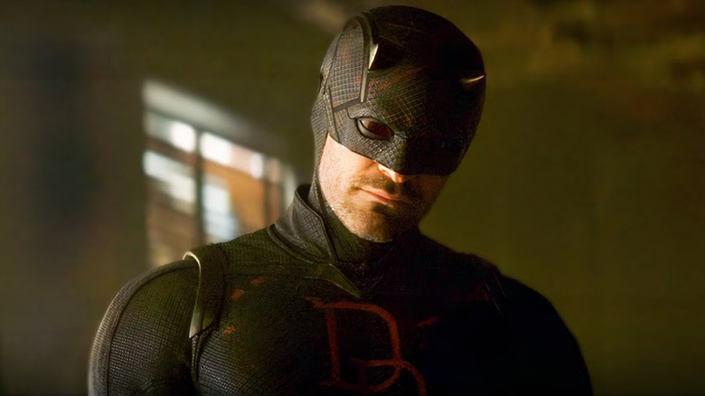 Charlie Cox as Daredevil in his black suit as he listens intently in Daredevil: Born Again