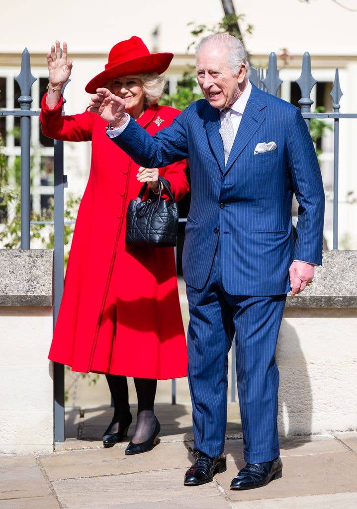 King Charles and Queen Camilla waving outside chapel