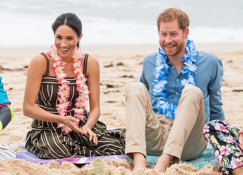 Prince Harry, Duke of Sussex and Meghan, Duchess of Sussex sitting on beach