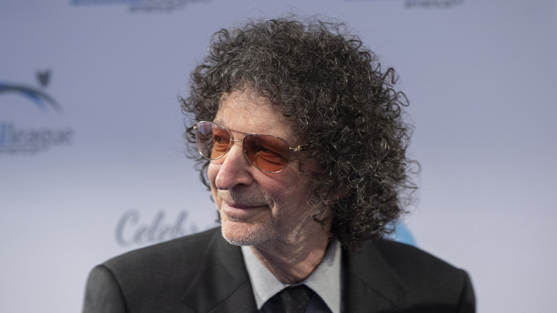 Howard Stern posing in aviators with orange lenses.