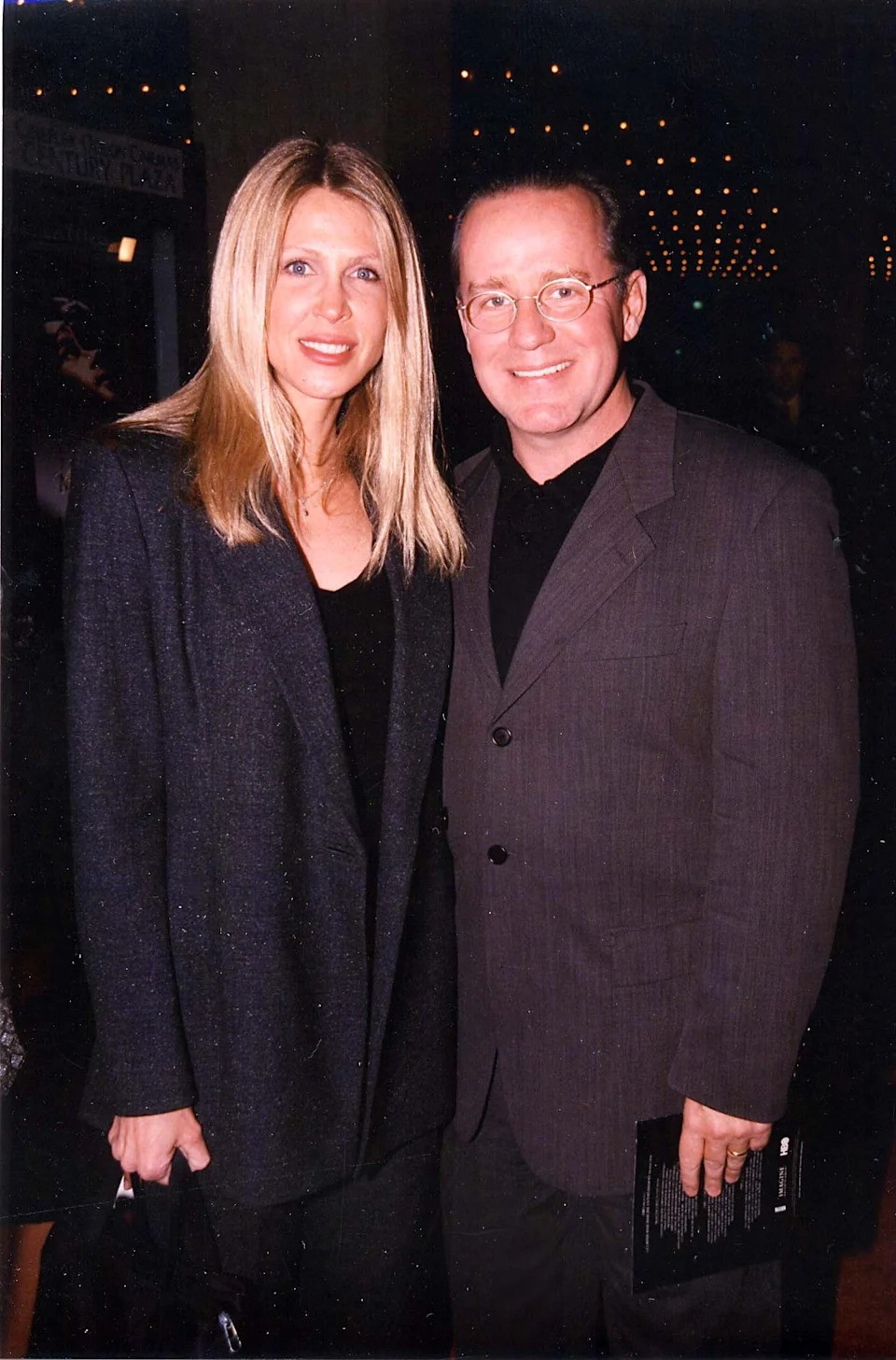 Brynn Omdahl and Phil Hartman smile while posing together at an event, both in formal attire