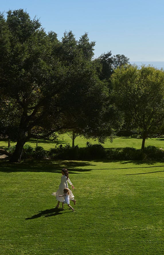 A joyful interaction between a woman and a child in a green park.