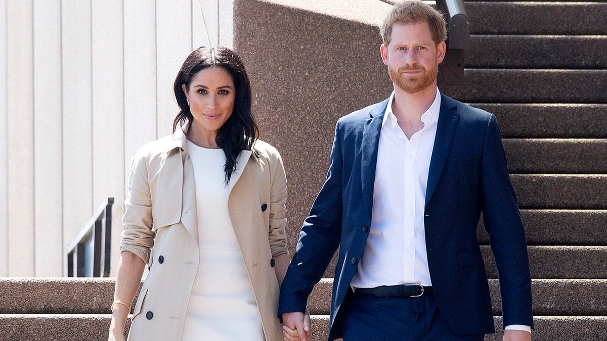 Prince Harry and Meghan Markle walking together holding hands at Sydney Opera House