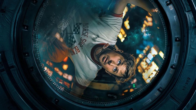 Ryan Gosling as Ryland Grace looking through the window of his ship in Project Hail Mary