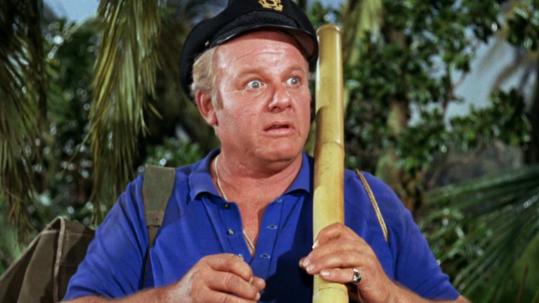 Alan Hale Jr.'s Skipper looks shocked as he stands in shrubbery in Gilligan's Island