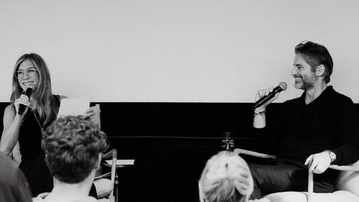 Jennifer Aniston standing on stage with boyfriend Jim Curtis