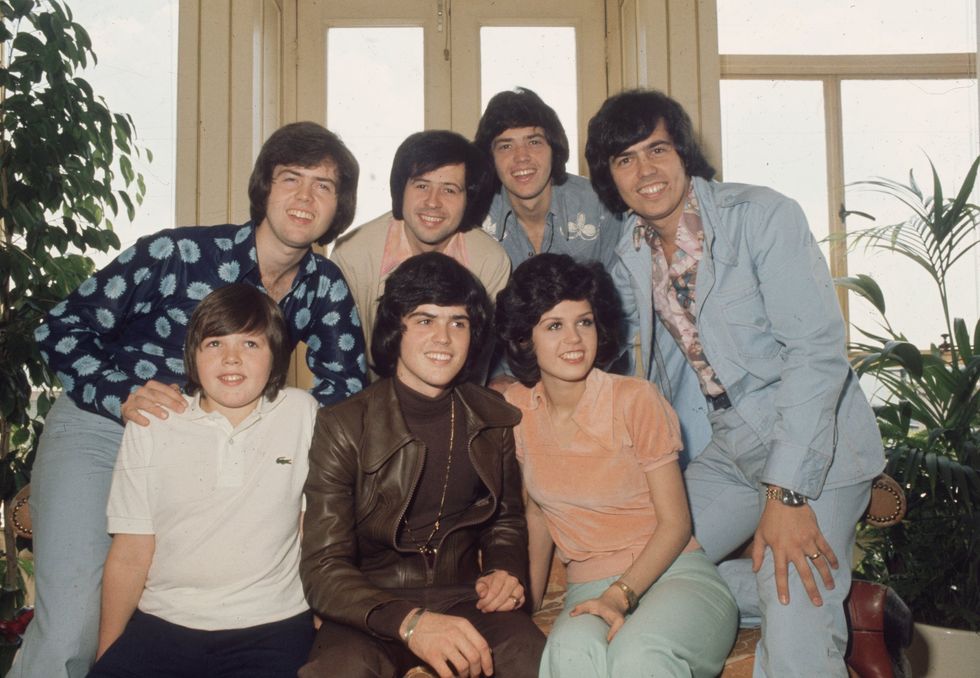 Jimmy, Donny and Marie Osmond. Behind them are brothers Alan, Wayne, Merrill and Jay