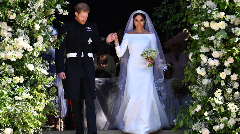 Meghan Markle stands next to Prince Harry wearing open-neck wedding dress