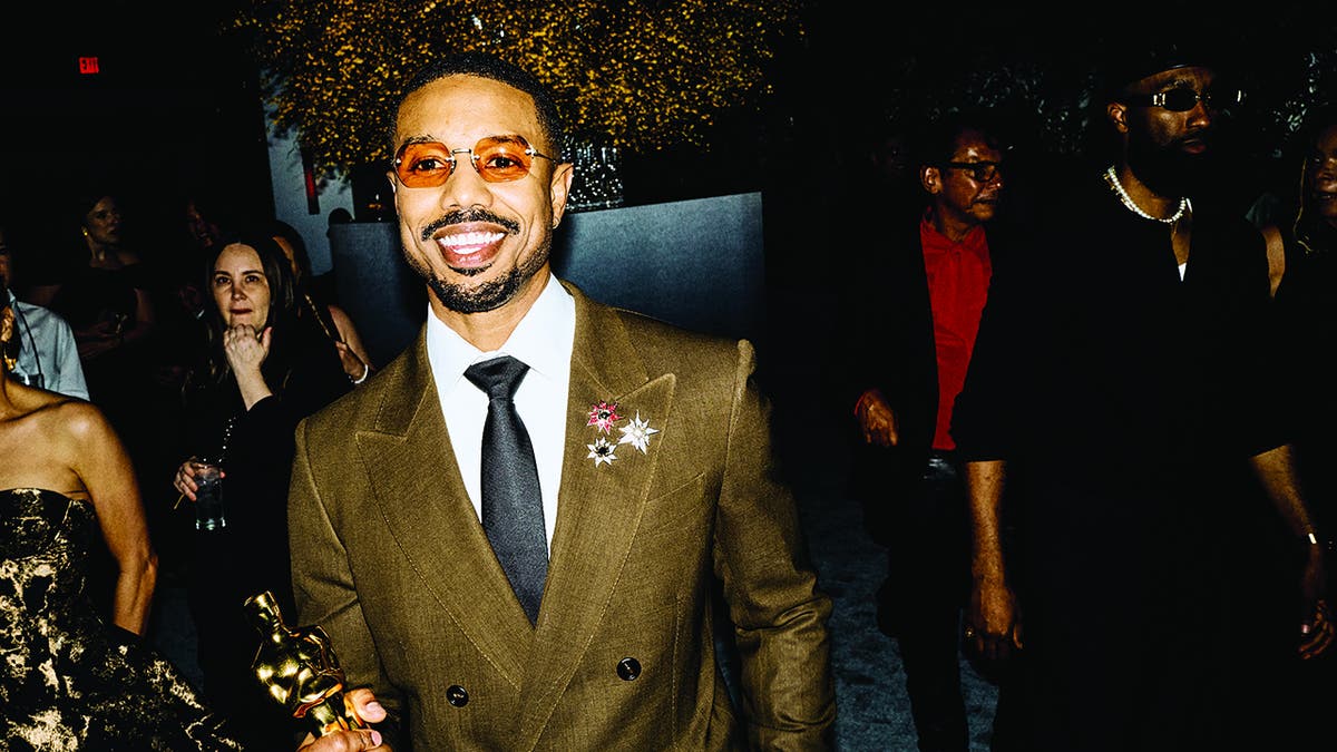 Michael B. Jordan carrying his Oscar inside Vanity Fair Oscar After Party