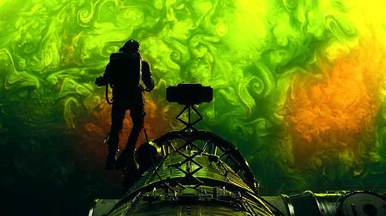 Ryan Gosling as Ryland Grace conducting a spacewalk outside his ship above a green planet in Project Hail Mary