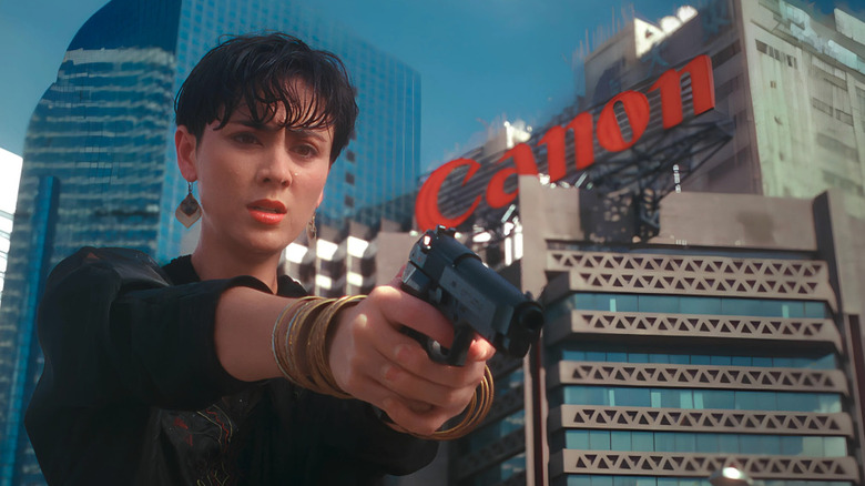 Joyce Godenzi as Mina, pointing a gun in She Shoots Straight
