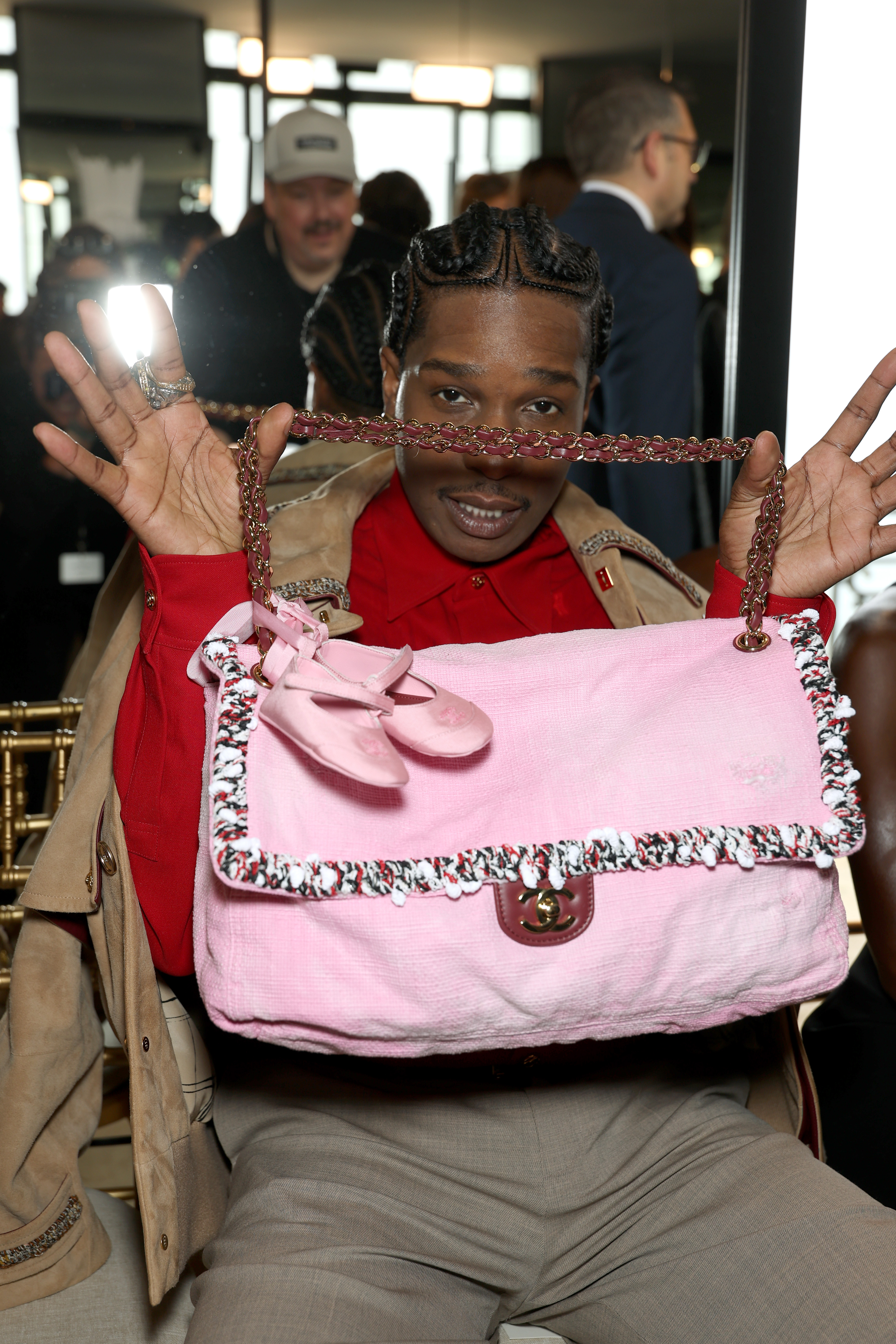ASAP Rocky holding up a Chanel maxi flap bag in the cruise show front row